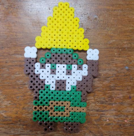 A character holding a triangle, all made of perler beads