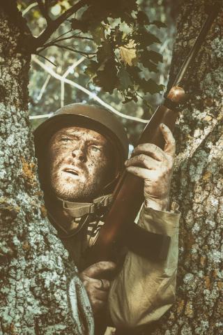 soldier hiding behind tree