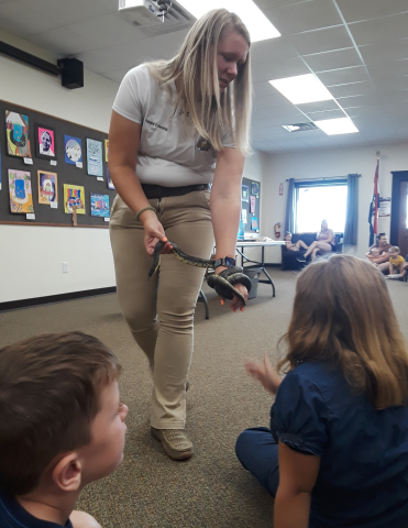 lady holding a snake in the library